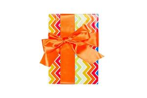 Christmas or other holiday handmade present in colored paper with orange ribbon. Isolated on white background, top view. thanksgiving Gift box concept photo