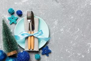 Holiday composition of Christmas dinner on cement background. Top view of plate, utensil and festive decorations. New Year Advent concept with copy space photo