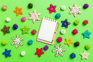 Top view of notebook. New Year decorations on green background. Festive stars and balls. Merry Christmas concept photo