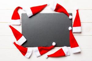 Festive set of plate decorated with Santa Claus hat on wooden background. Top view christmas dinner concept photo