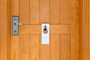 please do not disturb sign on Closed wooden door of hotel room photo