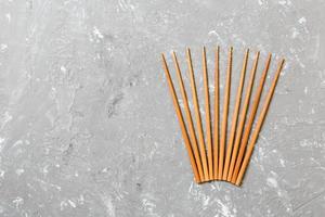 Many bamboo chopsticks on black cement stone background, top view with copy space. a lot of sushi sticks in the form of an ornament photo