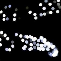 Abstract bokeh of white city lights on black background. defocused and blurred many round light photo