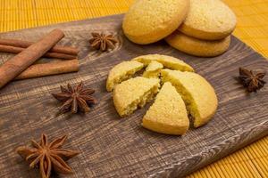 homemade gingerbread cookies, spices and cutting board on wooden background. holiday. photo