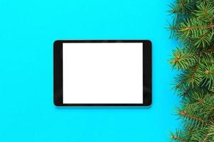 blank screen tablet on blue background, christmas time top view photo