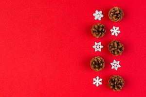 Top view of holiday composition made of pine cones and white snowflakes on colorful background. Winter time and Christmas concept with copy space photo