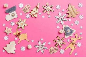 Top view of holiday decorations and toys on pink background. Christmas ornament concept with empty space for your design photo