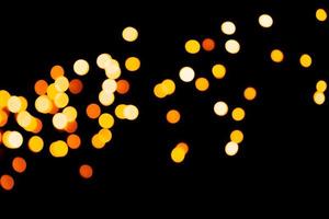 Unfocused abstract gold bokeh on black background. defocused and blurred many round light photo