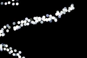 Abstract bokeh of white lights on black background. defocused and blurred many round light photo