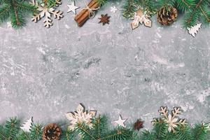 Christmas background with fir tree and snowflaces on gray cement table. Top view with copy space for your design. Toned photo