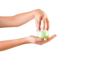 Female hand holding cream bottle of lotion isolated. Girl opening jar cosmetic products on white background photo