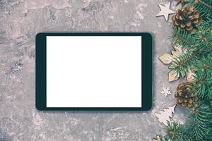 Digital tablet mock up with rustic Christmas gray cement background decorations for app presentation vintage, toned. top view with copy space photo