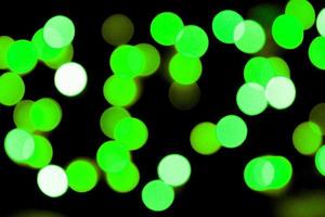Unfocused abstract colourful bokeh black background. defocused and blurred many round green light photo