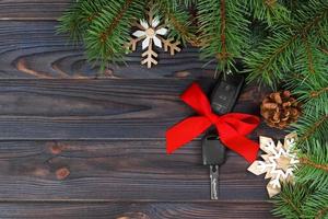 Close-up view of car keys with red bow as present on wooden background photo