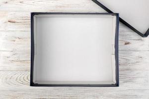 A empty blank white box on the desk top view on white wooden background photo