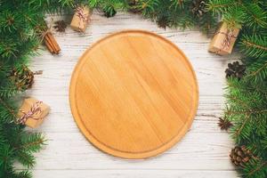 top view. Empty wood round plate on wooden christmas background. holiday dinner dish concept with new year decor photo