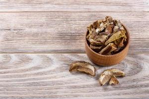 hongos shiitake secos en un arco, sobre una mesa de madera foto