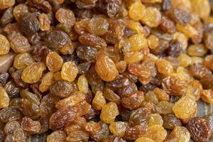 Dried yellow golden raisins on a board photo