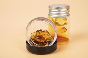 yellow extract wax from cannabis buds in container, marijuana thc distillate photo