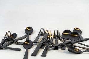 tenedores y cucharas de metal negro sobre un fondo blanco, México foto
