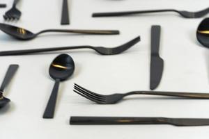 tenedores y cucharas de metal negro sobre un fondo blanco, México foto