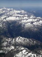 Snow covered mountain seen from a plane over the European Alps photo