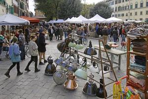 Florence, Italy, 2020 - People examine the display on a flea market in the center of Florence, Italy. photo