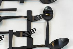 tenedores y cucharas de metal negro sobre un fondo blanco, México foto
