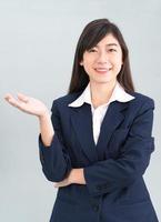 Asian woman in suit open hand palm gestures with empty space photo