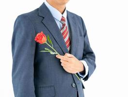 hombre de negocios en traje con rosa roja sobre blanco foto