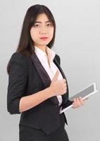 Young women standing in suit holding digital tablet photo