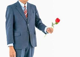 Businessman in suit with red rose on white photo