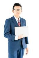 Businessman portrait in suit holding a laptop over white background photo