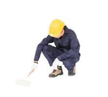 Worker in a uniform using a paint roller is painting invisible floor photo