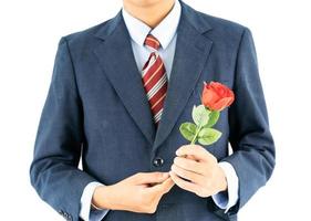 Businessman in suit with red rose on white photo