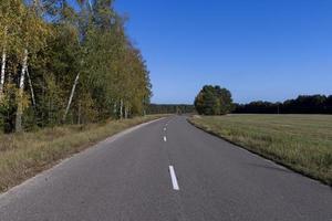 Paved road in the autumn season in sunny weather photo