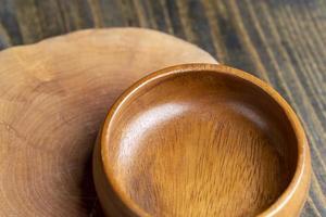 cuenco de madera sobre mesa de madera, cuenco redondo vacío para comestibles y comida foto