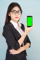 mujeres sosteniendo un teléfono inteligente simulado pantalla verde foto