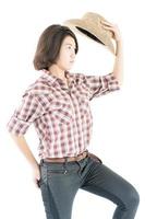Young woman in a cowboy hat and plaid shirt with hand on her hat photo