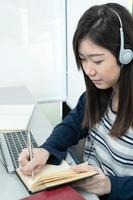 Young female long hair sitting in living room and learning online photo