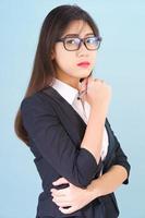 Young asian girl wearing suit with support hand on chin photo