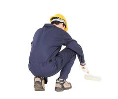 Worker in a uniform using a paint roller is painting invisible floor photo