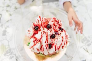 pastel de helado y la mano de un niño al lado foto