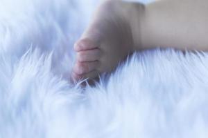Small child's feet on white bedding. photo