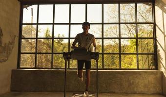 Man running in a gym on a treadmill concept for exercising, fitness and healthy lifestyle. photo