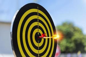 Two dart hit it's target on a red background, concept for success,darts motion blur. photo