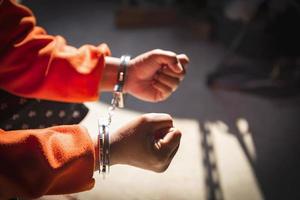 Desperate criminal man sitting on the floor in handcuffs. She arrested for robbery. photo