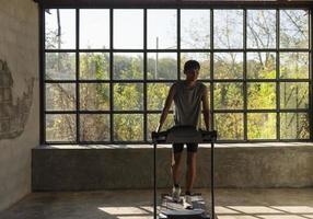 Man running in a gym on a treadmill concept for exercising, fitness and healthy lifestyle. photo