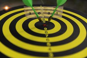 Two dart hit it's target on a red background, concept for success,darts motion blur. photo