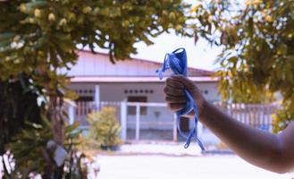 Man holding used medical mask symbol the end of quarantine isolation and beginning of normal life again. Ending of pandemic korona virus. photo